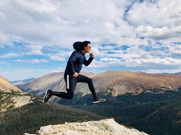 Elijah Clemente, Chsatswood Chiropractor, jumping with mountain scenery behind him in sports gear